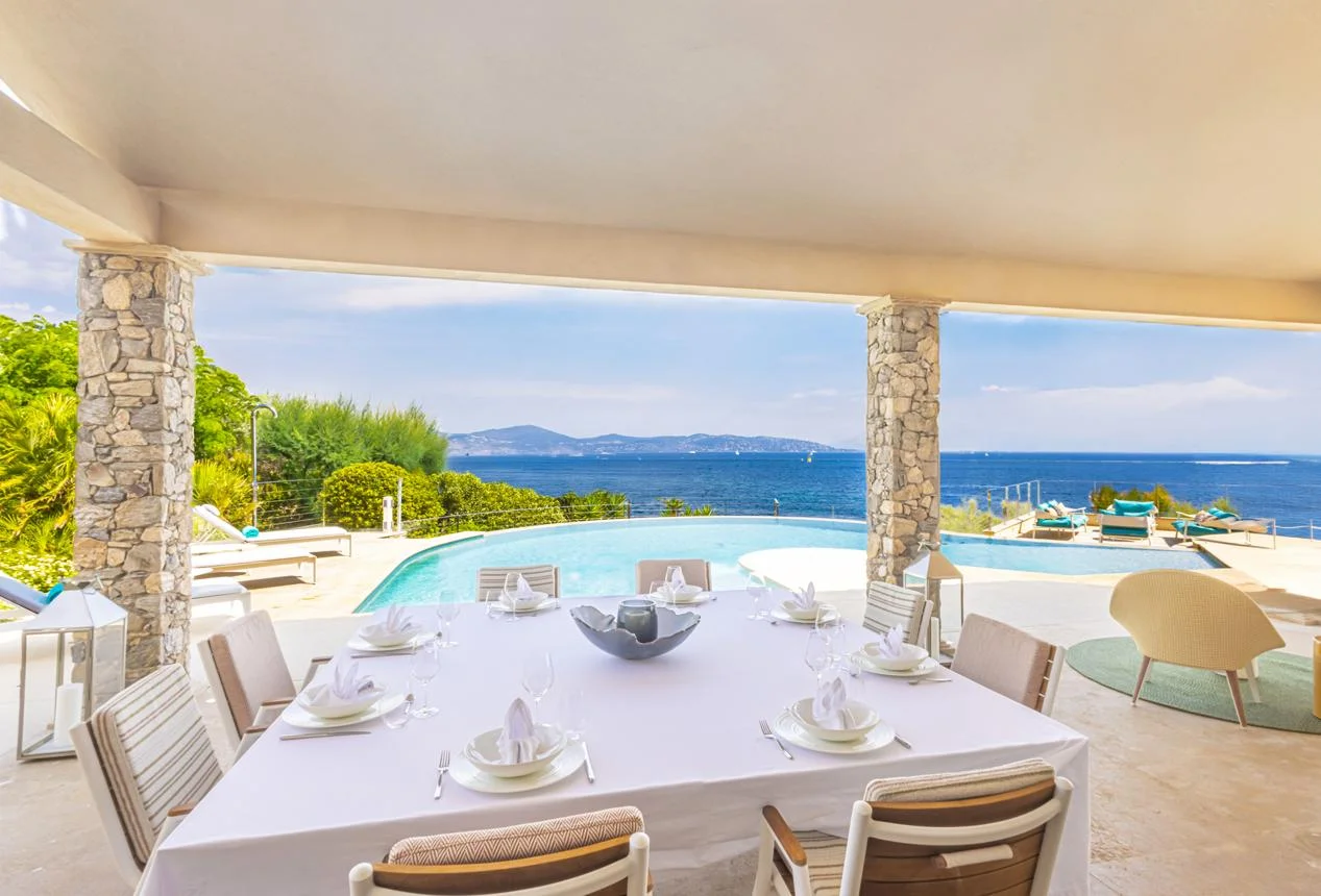 Eine für Feriengäste vorbereitete Villenterrasse mit Pool und Meerblick